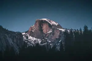 a mountain is seen at night with stars above it