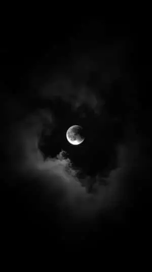 Full Moon Illuminating Dark Stormy Clouds in a Mysterious and Eerie Night Sky  