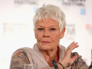 Judi Dench striking a pose with a playful hand gesture