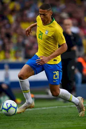 Richarlison De Andrade skillfully dribbling a football during a match